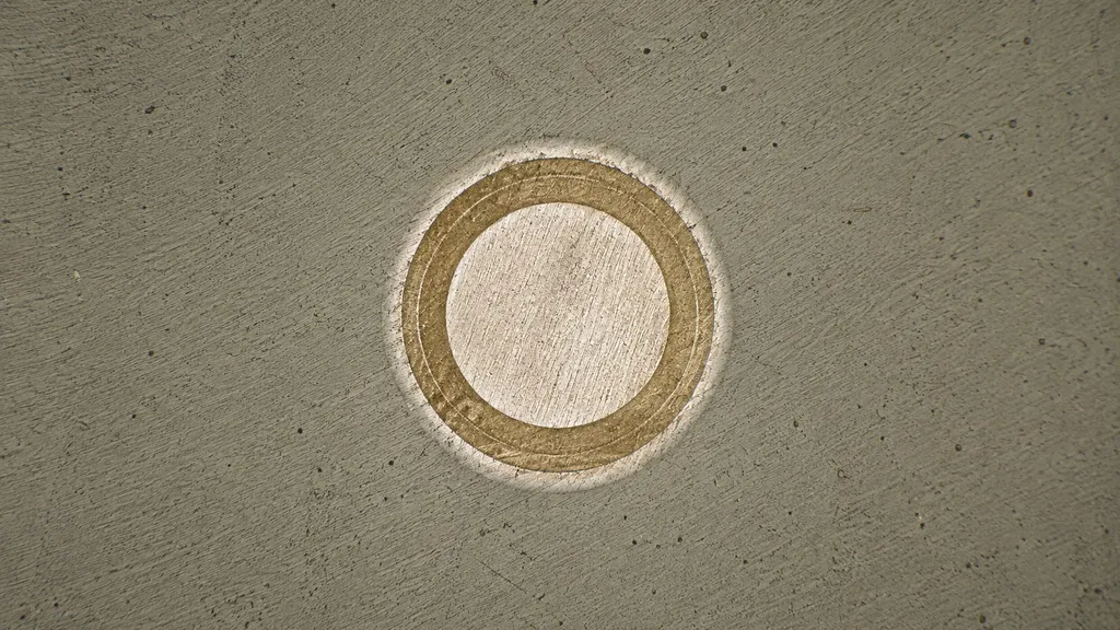 A ball crater ground through a multilayer coating, showing concentric rings where each layer is exposed